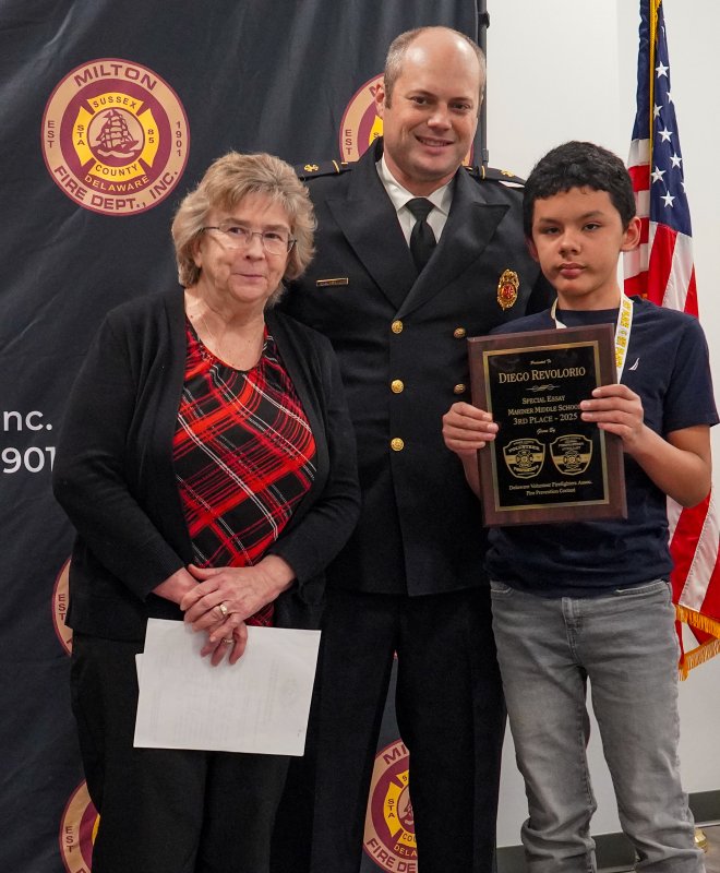 Seventh-grader Diego Revolorio of Mariner Middle School is presented the first-place award by Mary Ann Argo and Bryan Reynolds.